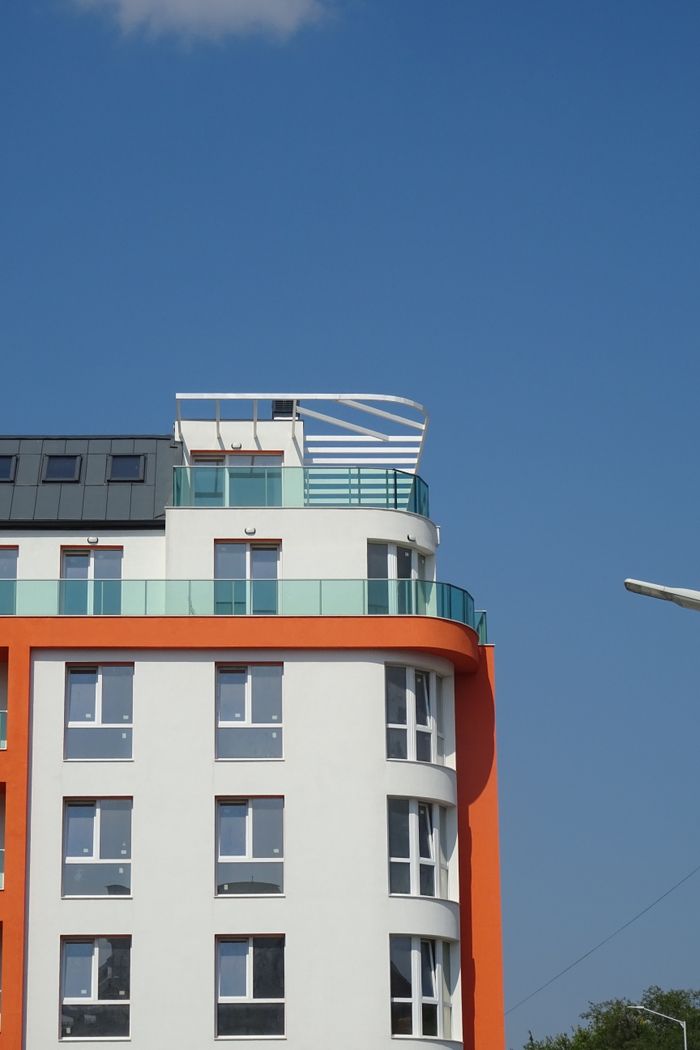 cta-bg Contemporary apartment building against a clear blue sky. Ideal for urban architecture concepts.