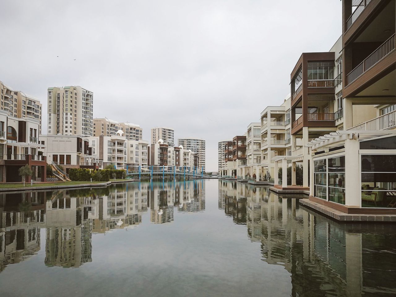 home-services-01 Modern residential buildings reflecting in a tranquil urban canal.