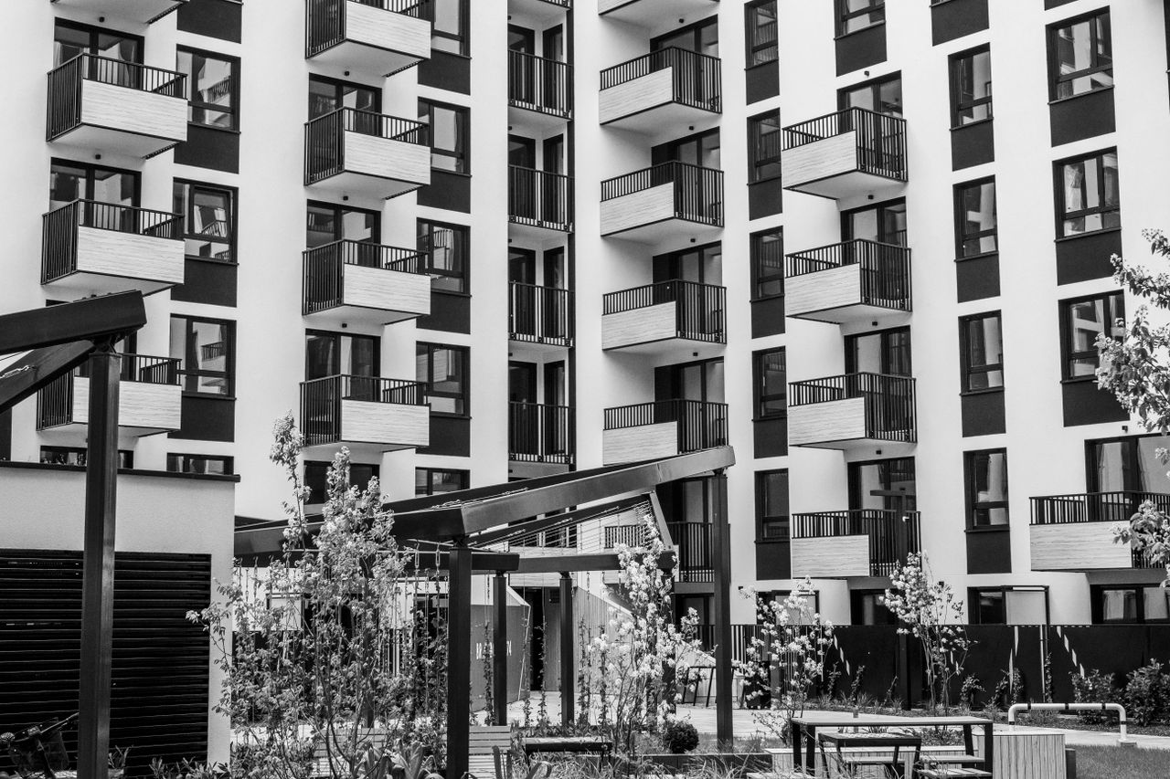 home-hero-bg Contemporary urban apartment building with balconies and courtyard, black and white.